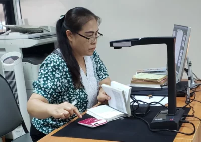 Librarian using a specialised book scanner to add to their electronic library.
